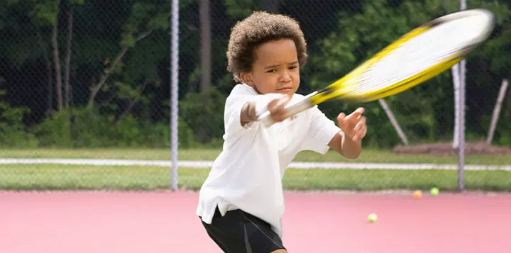 Niño practicando tenis 