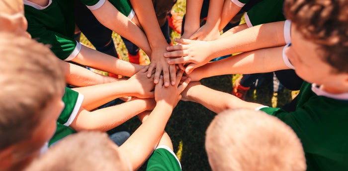 Grupo de niños practicando deporte mostrando compañerismo y trabajo en equipo