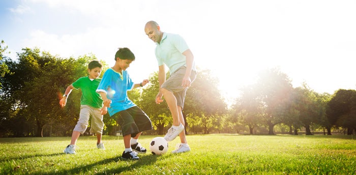 papá e hijos felices jugando fútbol