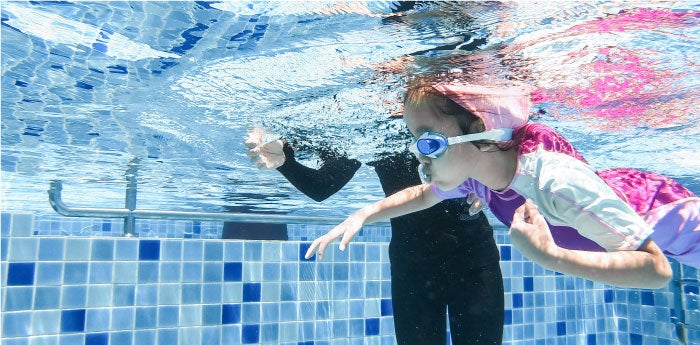 Niña deportista nadando en una piscina