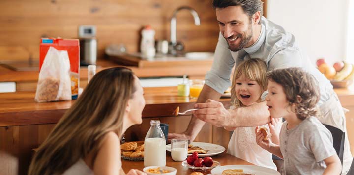 papá, mamá e hijos comparten desayuno nutritivo