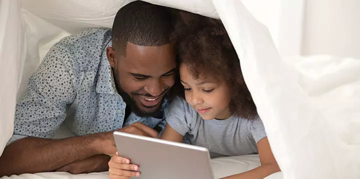 Padre e hija mirando contenido en una clase virtual