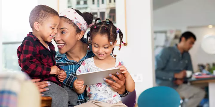 Madre compartiendo tiempo con sus dos hijos a través de una tableta digital  