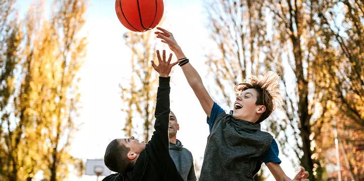 Hermanos practicando baloncesto en familia  
