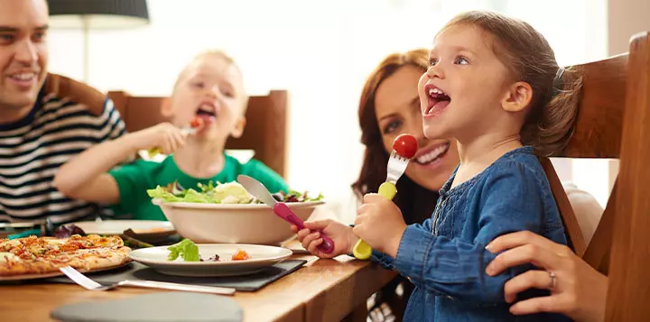 Niños cenando junto a sus padres