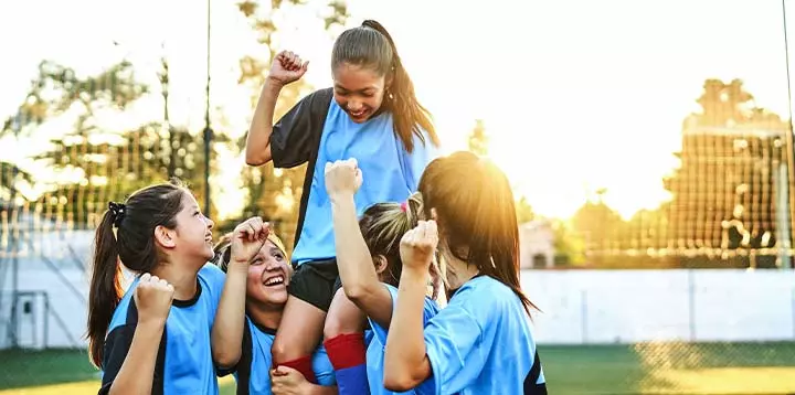 Niñas celebrando su triunfo en el futbol