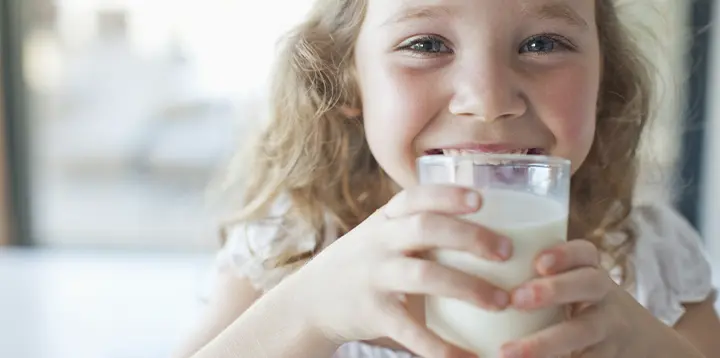 Niña disfrutando de un vaso delicioso de leche