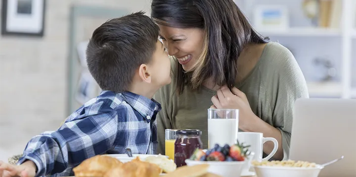 Mamá e hijo disfrutan de un desayuno balanceado con pancakes y fruta 