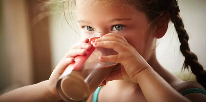 Niña disfrutando de un vaso de MILO®