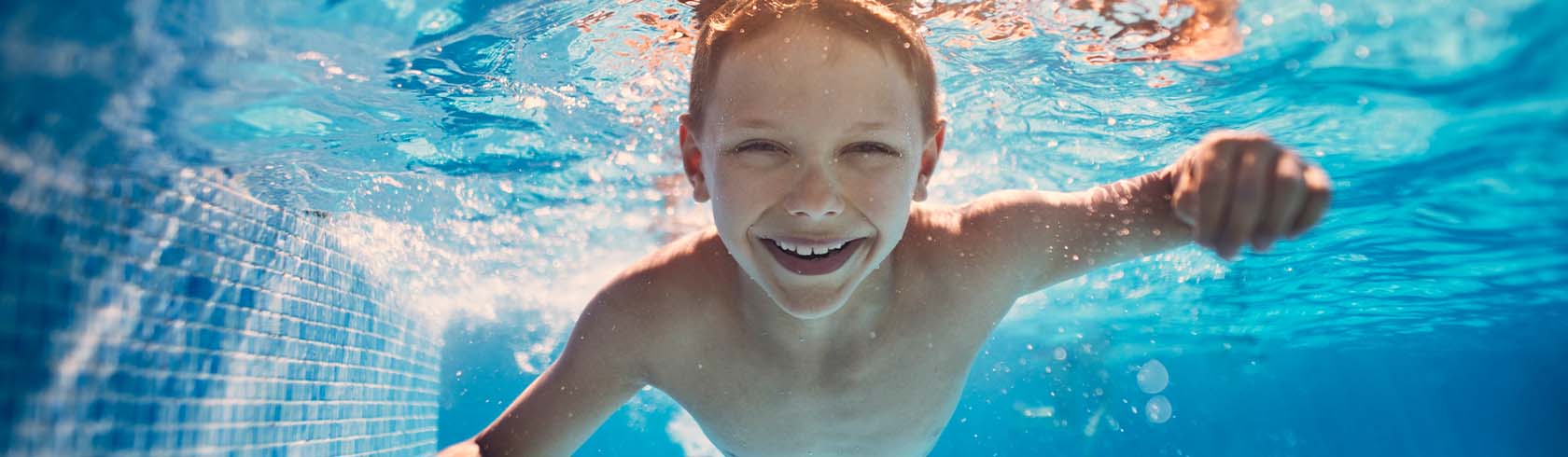Un niño nadando y disfrutando de los beneficios de la natación 