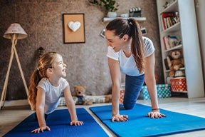 Una mamá y su hija haciendo ejercicios de yoga para niños