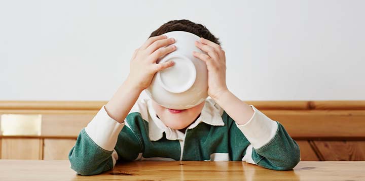 Niño tomando cereal con sabor a chocolate y malta  