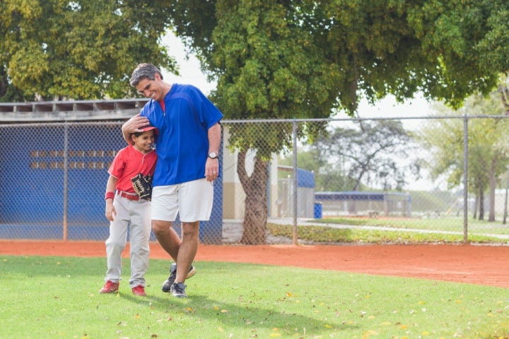 Papá abrazando a su hijo luego de practicar su deporte favorito