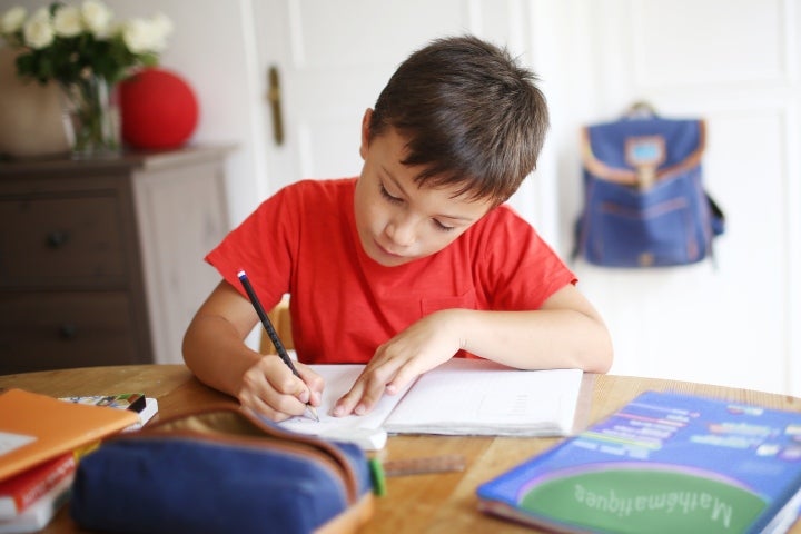 Niño escribiendo en un cuaderno como parte de su estudio