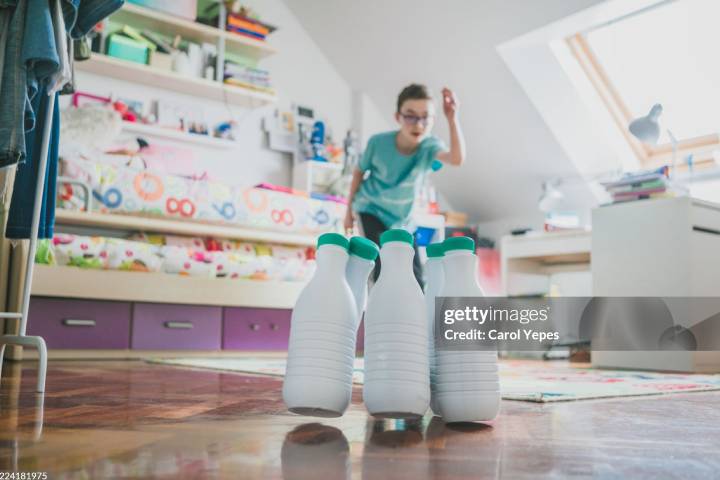 Niño jugando con bolos hechos con material reciclado