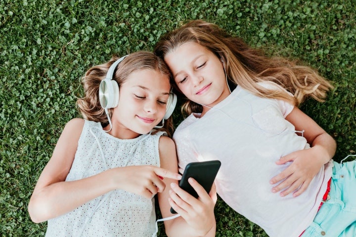 Dos niñas escuchando música desde el celular
