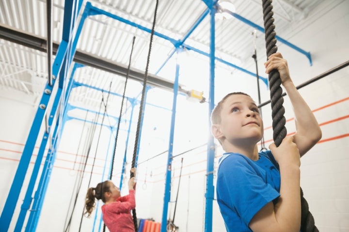 Niños subiendo la cuerda como juego predeportivo.