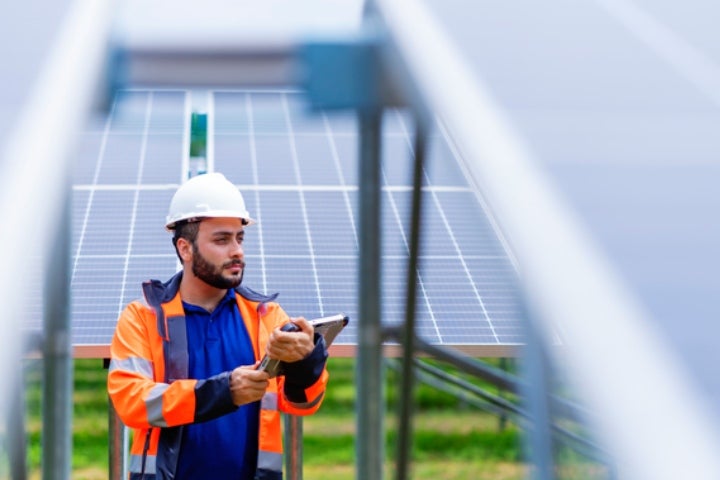 Técnico revisando la instalación de paneles solares en campo.