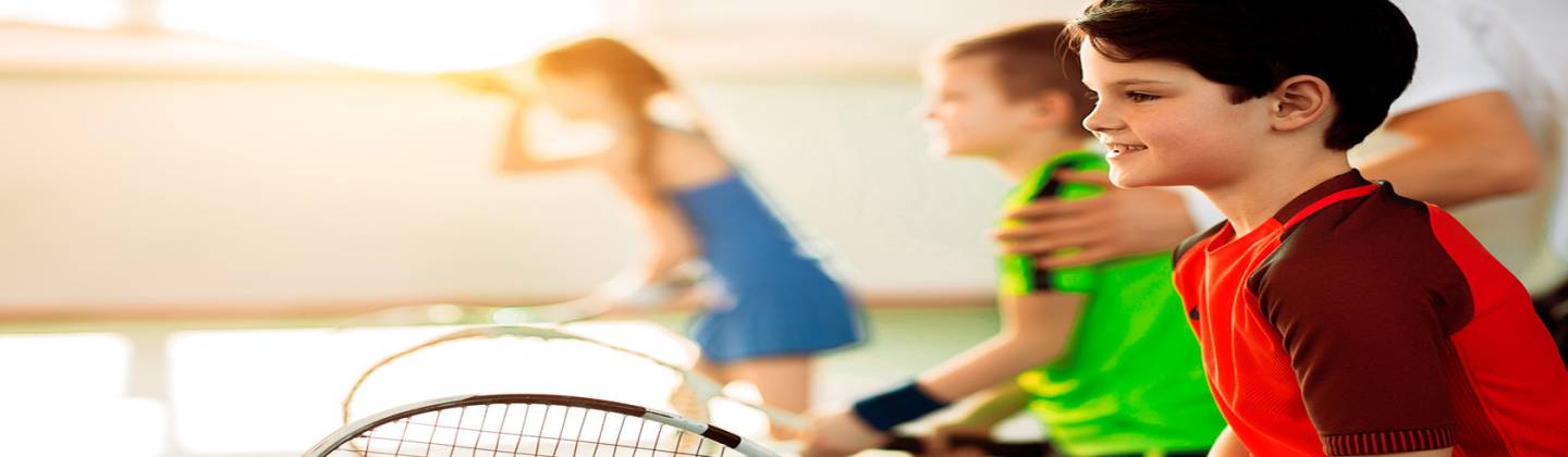Niños tenistas atentos a las indicaciones de su profesor