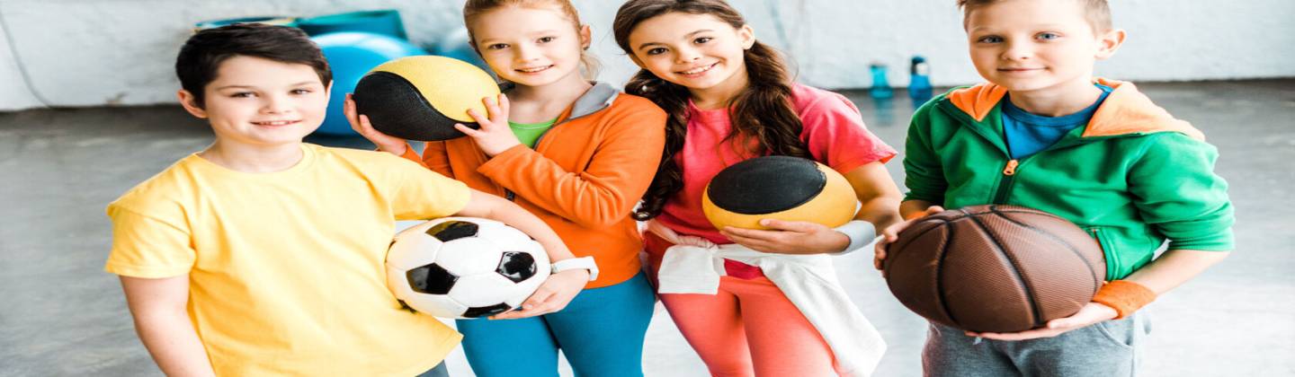 Niños deportistas posando con diferentes tipos de balón