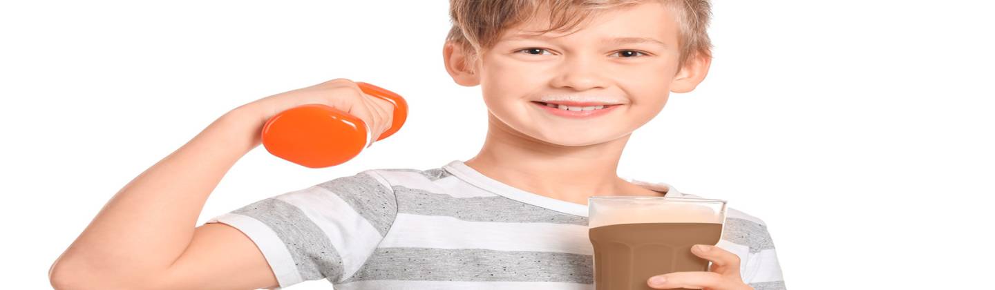 Niño sonriente mientras sostiene un vaso con leche y una mancuerna