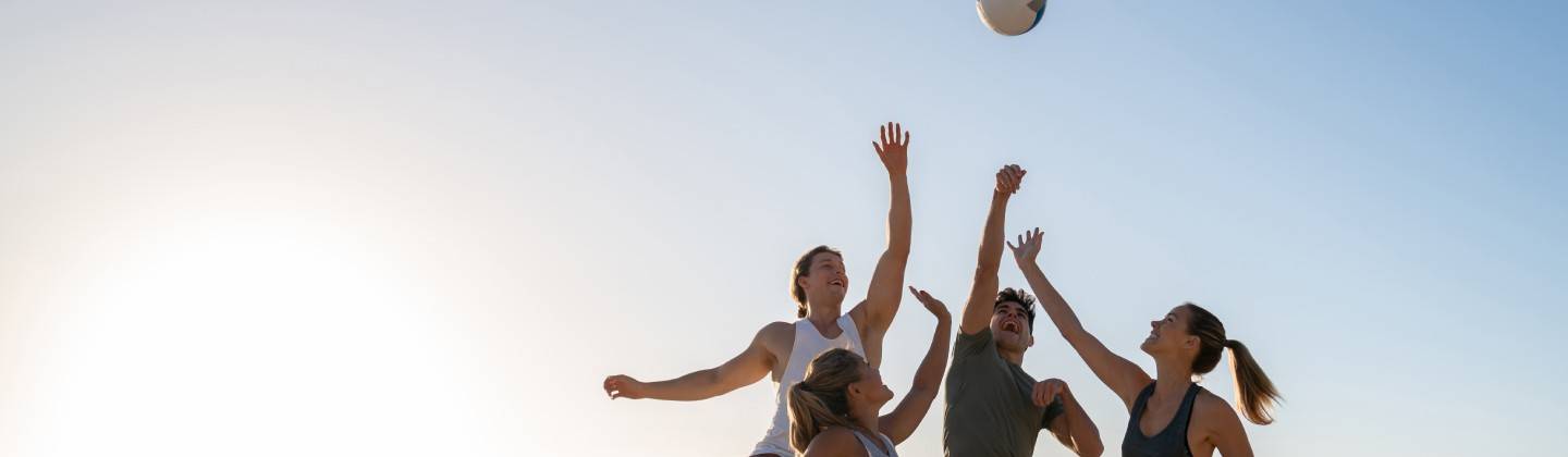 Grupo de mujeres jugando voleibol como deporte en equipo
