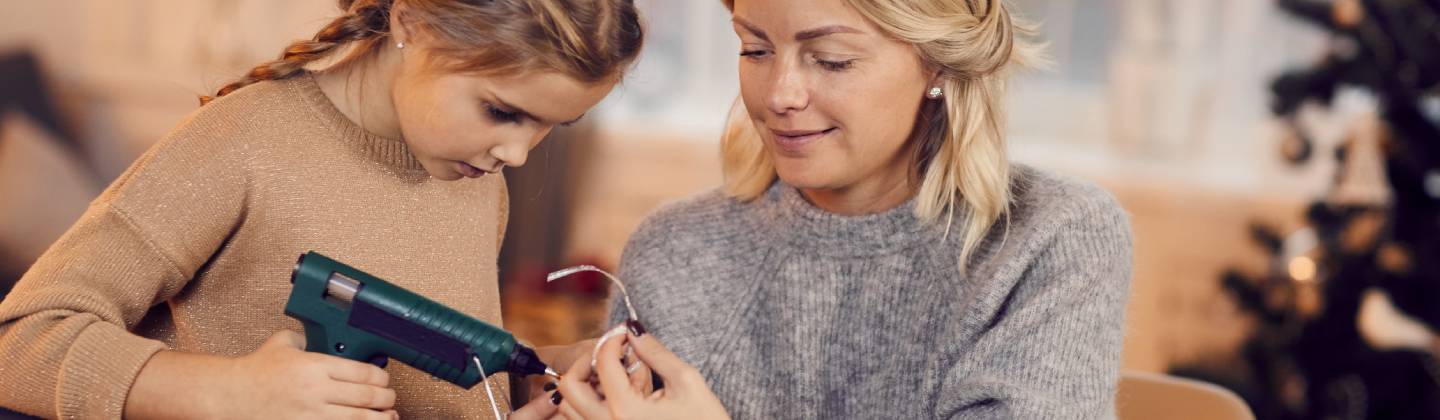 Mamá e hija haciendo manualidades navideñas con materiales reciclados
