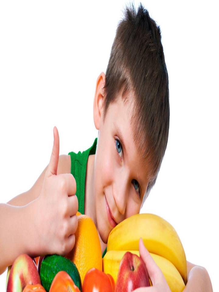 Niño abrazando frutas y verduras mientras tiene el pulgar arriba