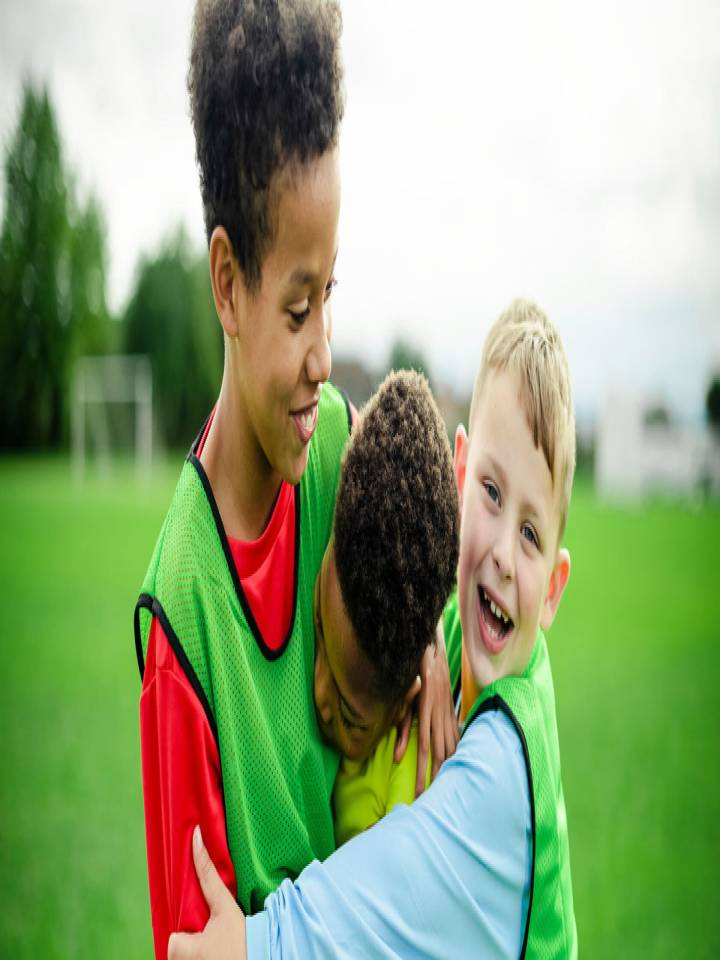 Niños futbolistas abrazados