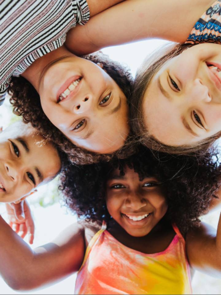 Cuatro niñas abrazadas sonriendo