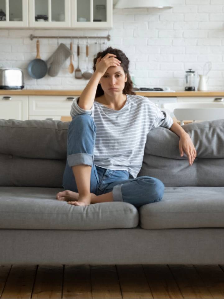 Mujer sentada en un sofá con falta de energía