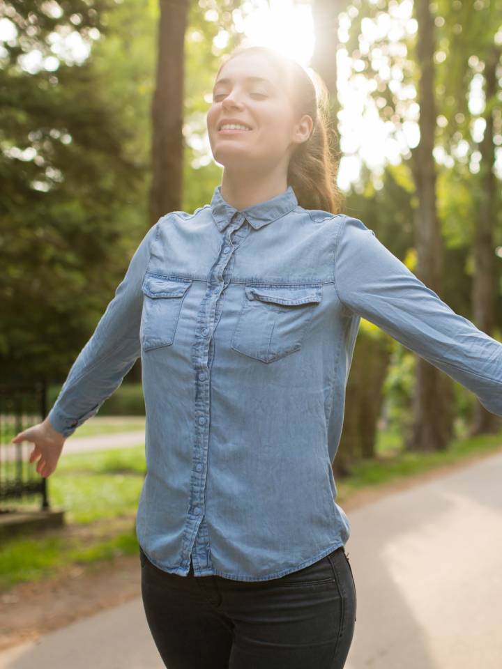 Mujer disfrutando del aire libre con los ojos cerrados