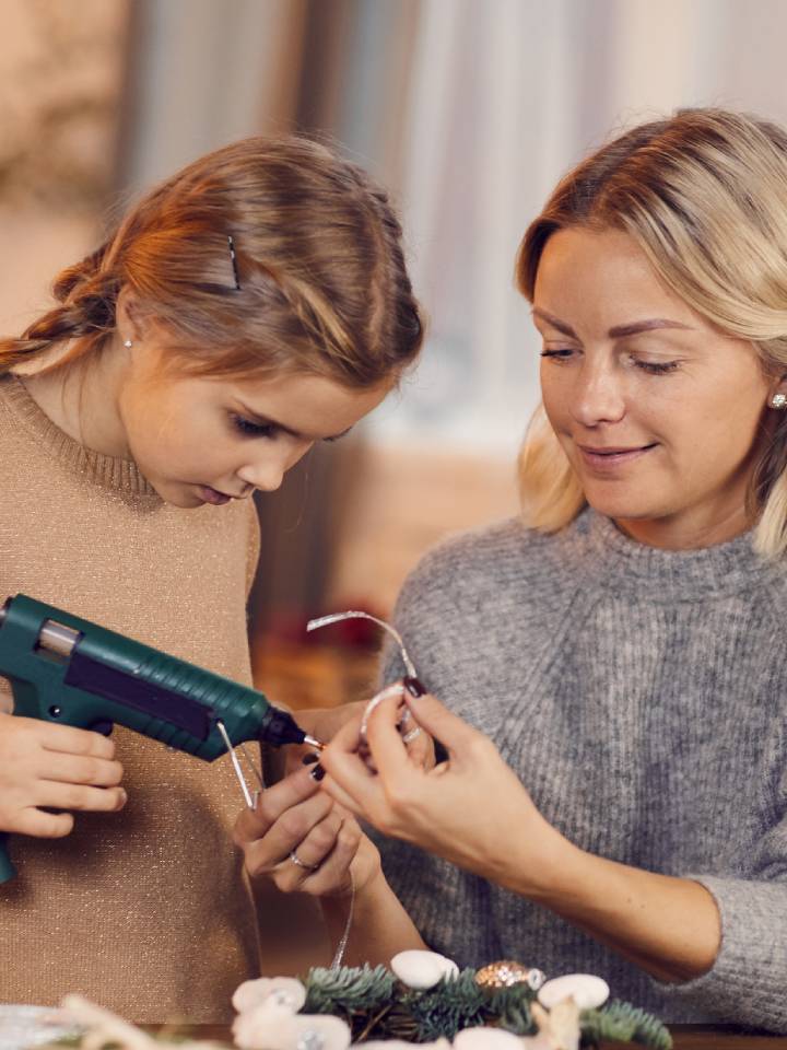 Mamá e hija haciendo manualidades navideñas con materiales reciclados