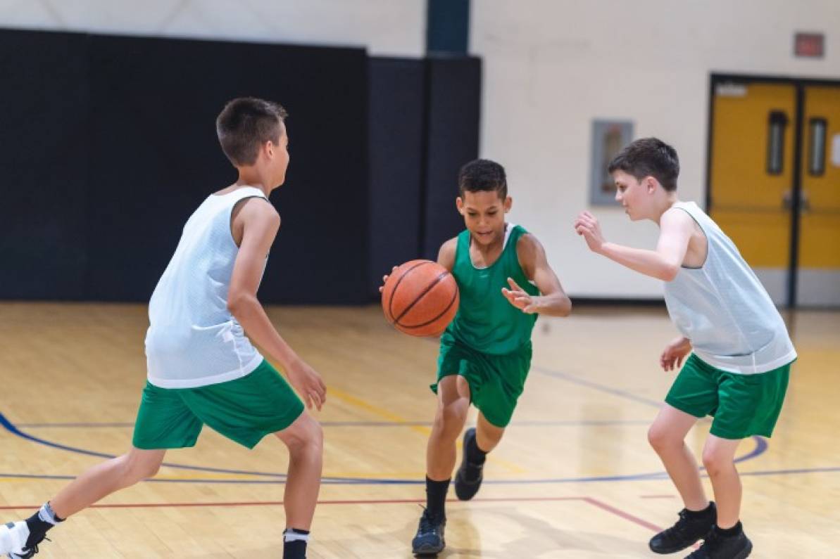 Niños jugado Baloncesto como un deporte en equipo