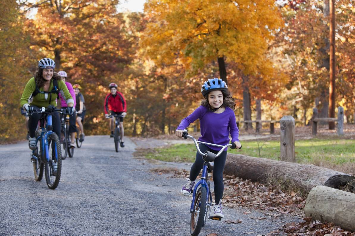 Niña montando bicicleta con su mamá