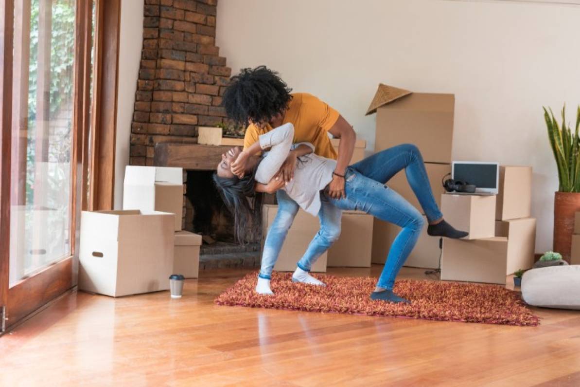 Pareja practicando baile deportivo desde la sala de su hogar.